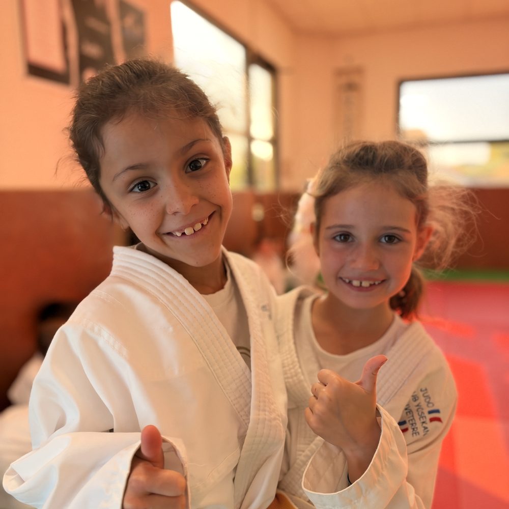 Deux judokates souriantes, pouces levés